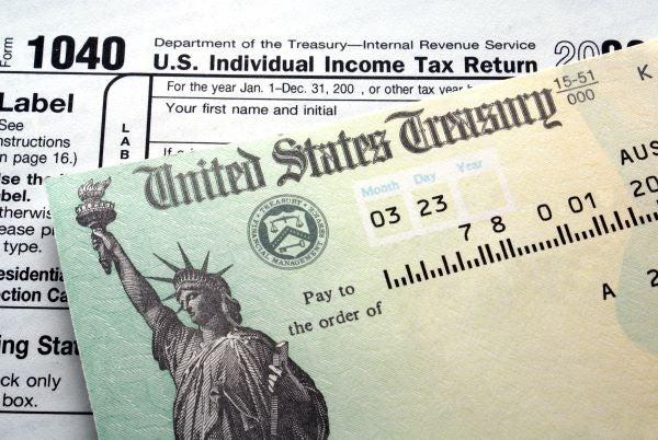A 1040 tax form is partially covered by a United States Treasury check.